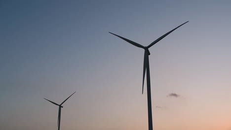 wind turbines silhouette against the blue-sky during sunset, clean alternative energy in thailand and mainland southeast asia