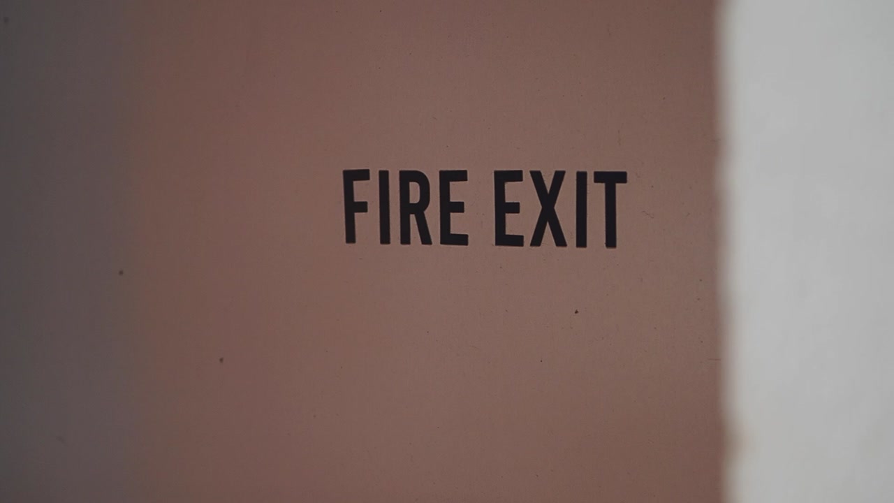 Fire Exit Sign on a Wall with Changing Light