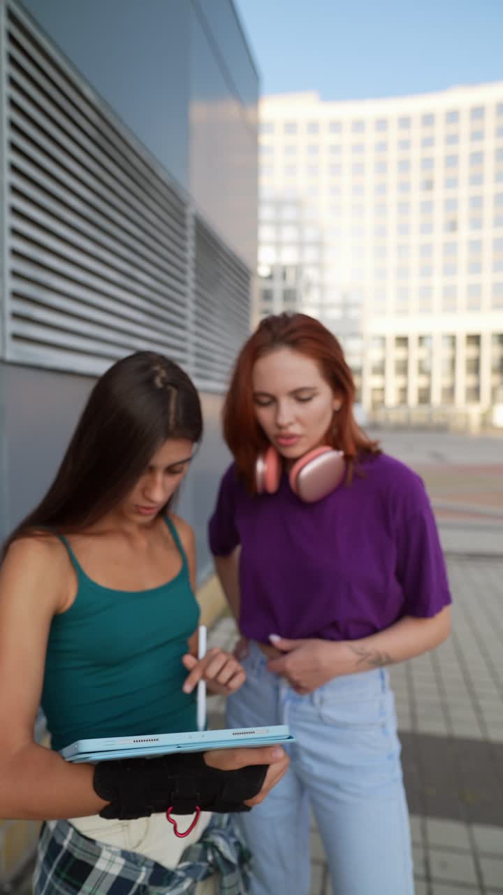 dos mujeres colaborando en una tableta de dibujo digital al aire libre
