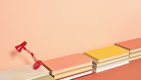 pequeña lámpara de escritorio roja saltando de un libro a otro. animación de stop motion creativa