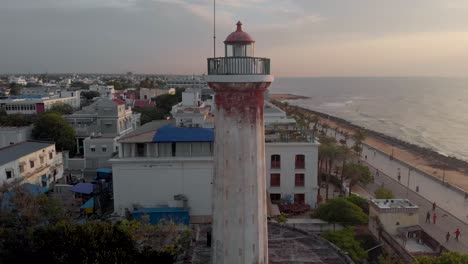 Aerial-Crane-Up-shot-of-an-Old-Light-House-near-the-shores-of-Pondicherry-Rock-Beach-shot-with-a-drone-in-4k