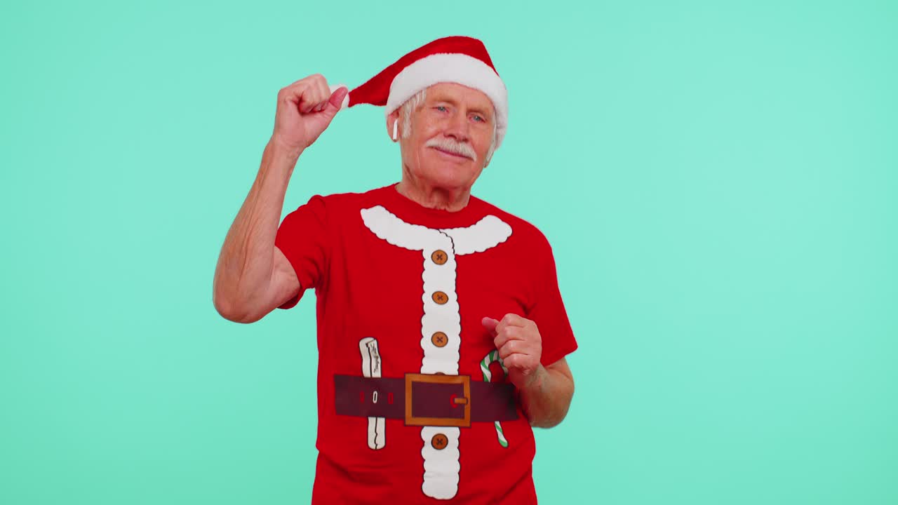 크리스마스 할아버지가 이어폰을 통해 음악을 듣고, 디스코를 춤추고, 재미를 즐기고 있습니다.