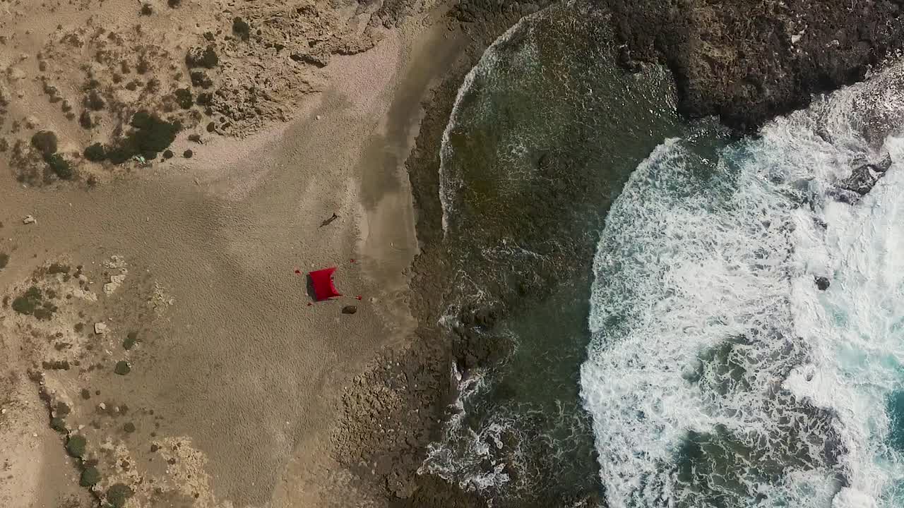 Drone flies above lagoon with tent FHD