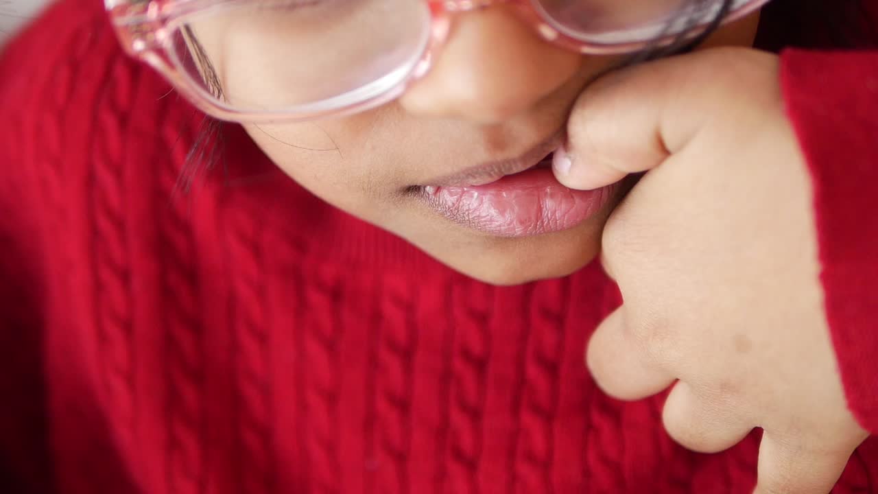retrato en primer plano de una mujer joven mordiéndose las uñas