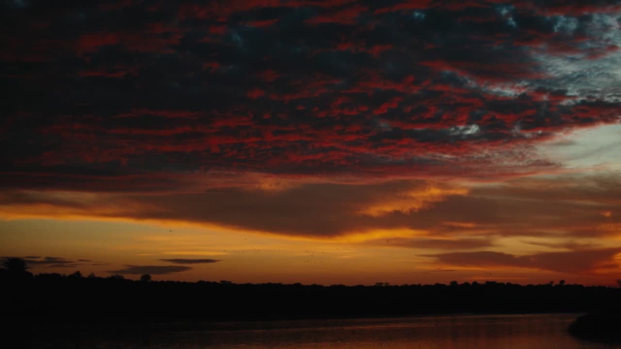 Dramatischer Himmel mit lebendigen Wolken in der Dämmerung über einem afrikanischen Fluss