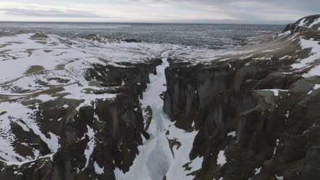 drohnenaufnahme des fjadrargljufur-canyons, einem natürlichen wahrzeichen islands an einem kalten wintertag