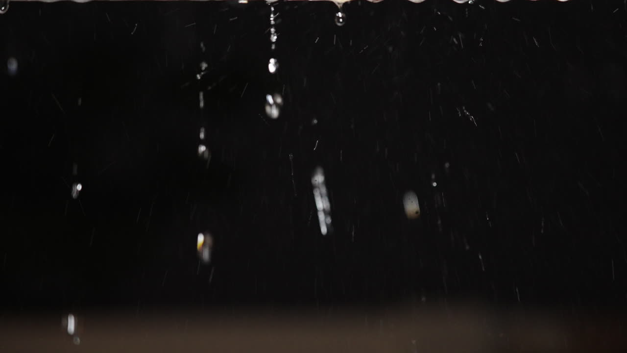 Close-up of Raindrops Falling and Water Dripping at Night