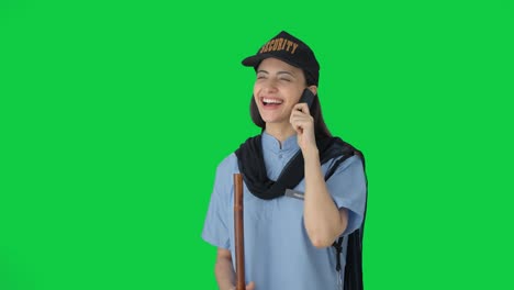 Happy-Indian-female-security-guard-talking-to-someone-on-call-Green-screen