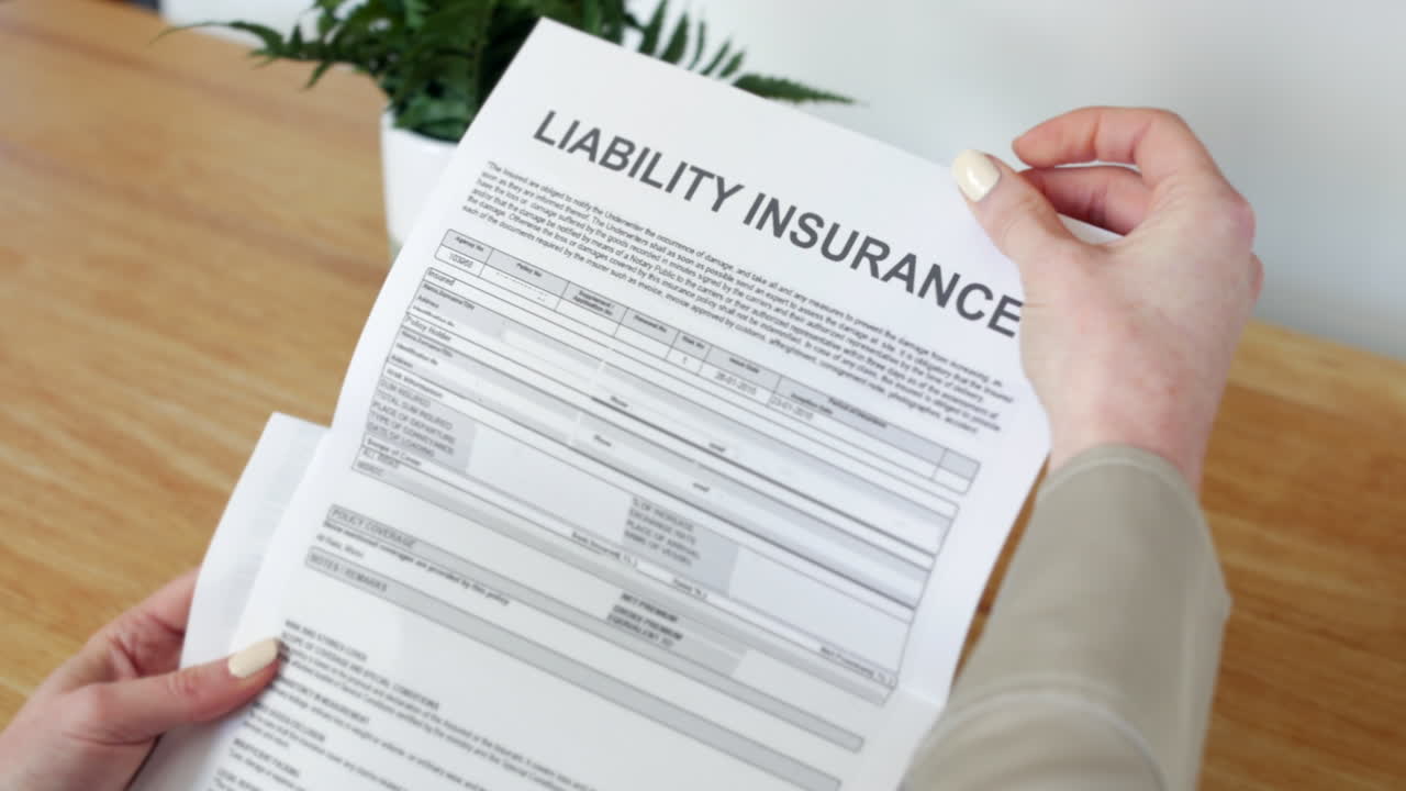 una mujer abriendo una carta de documento de seguro de responsabilidad que describe su póliza y los detalles de la cobertura