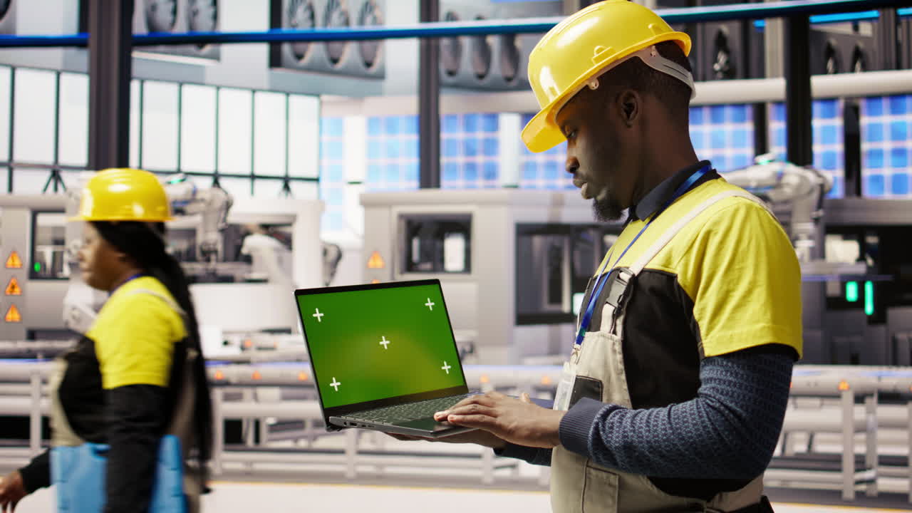 Vertical video Engineer in smart factory using green screen laptop to analyze IoT sensors data
