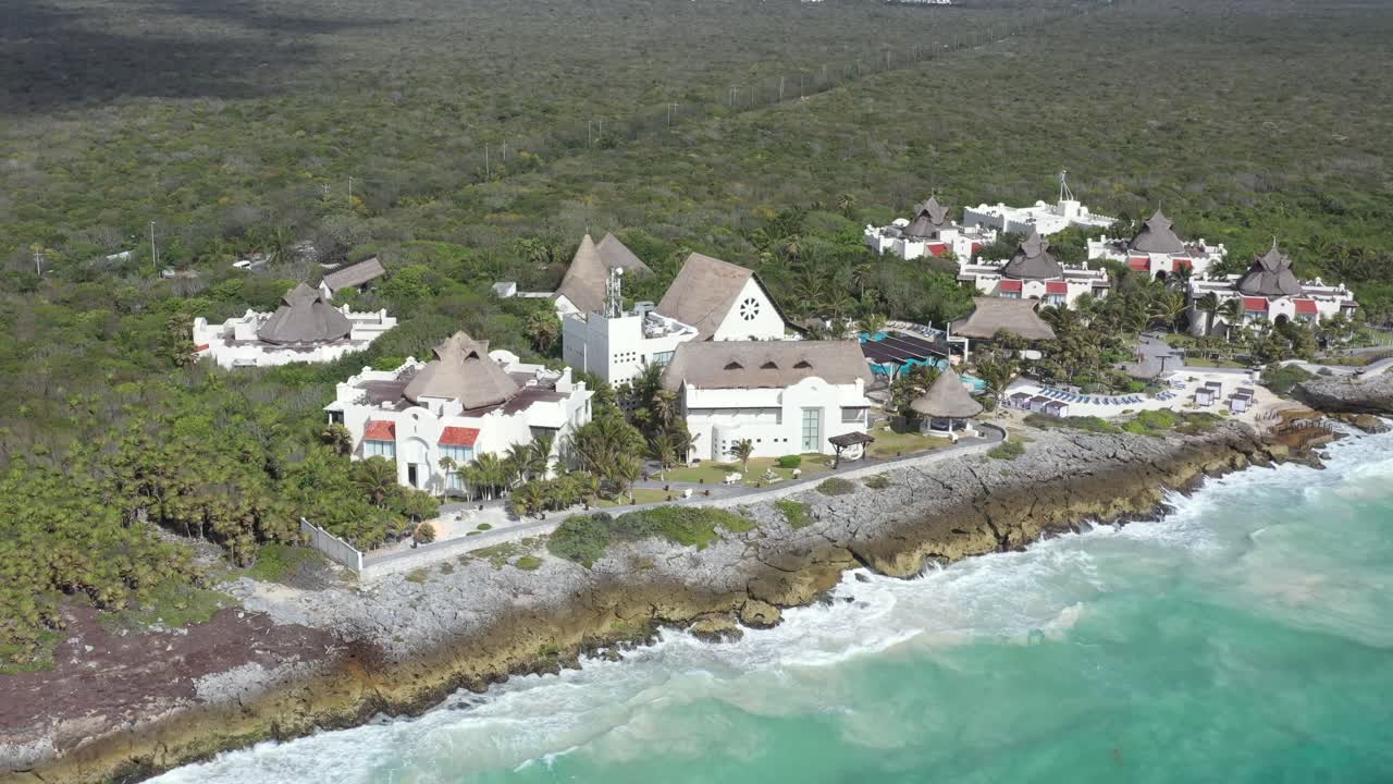 toma aérea de un resort de lujo con épicas vistas al mar caribe a la luz del sol - tulum, méxico