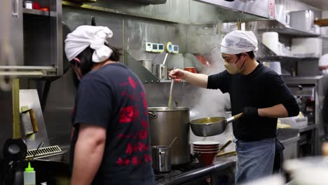 two chefs working together in a steamy kitchen