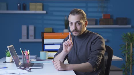 Businessman-listening-attentively-to-the-camera-in-his-office-and-rejecting-it-negatively.