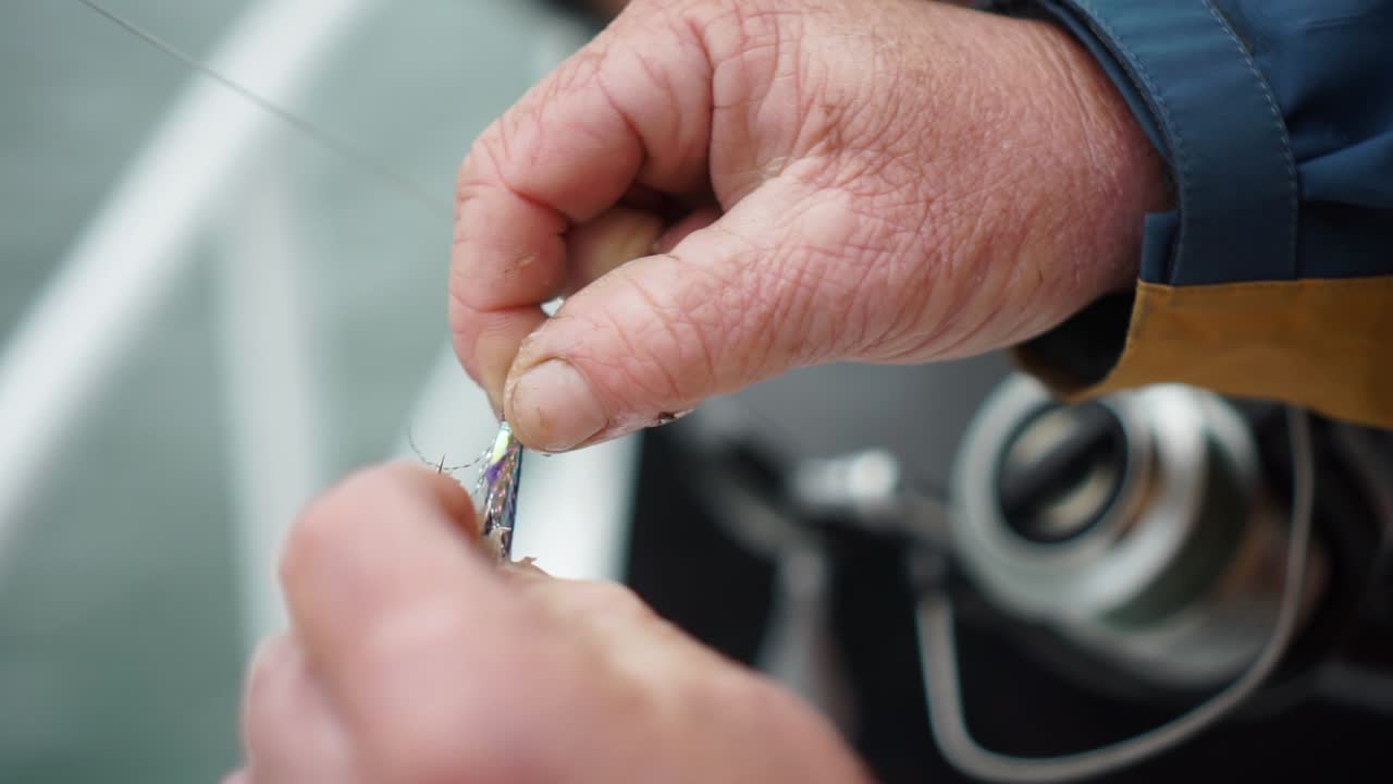 cámara lenta - el hombre pone peces de cebo en el anzuelo del señuelo