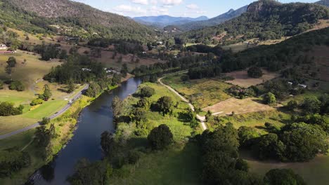 a high view drone video flying along a small river through a scenic valley close to the popular mount warning ex-volcano