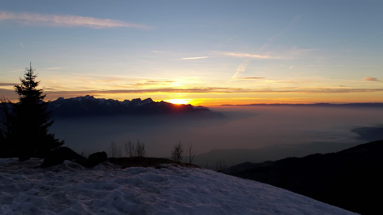 toma aérea de la puesta de sol sobre el mar de niebla, alpes suizos en el paisaje nevado de fondo