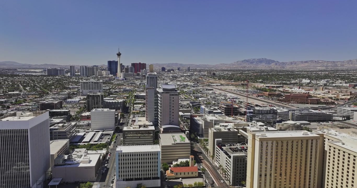Las Vegas, Nevada, vue aérienne v193 : survol à basse altitude au-dessus des tours d'hôtels historiques du centre-ville vers le Strat, la ligne d'horizon du Strip et les montagnes environnantes. Filmé avec Mavic 3 Pro Cine - 2 mai 2024