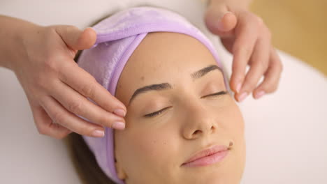 mujer recibiendo un masaje facial en un spa