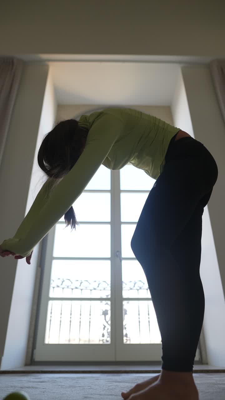 창문 근처 에서 요가 를 연습 하는 여자