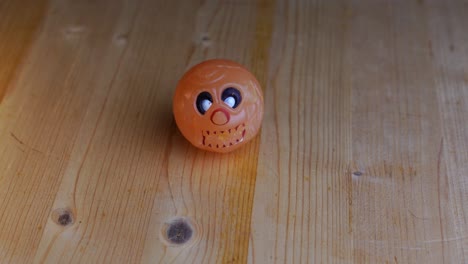 Weißer-Runder-Totenkopf-Hüpfball-Liegt-Auf-Einem-Holztisch