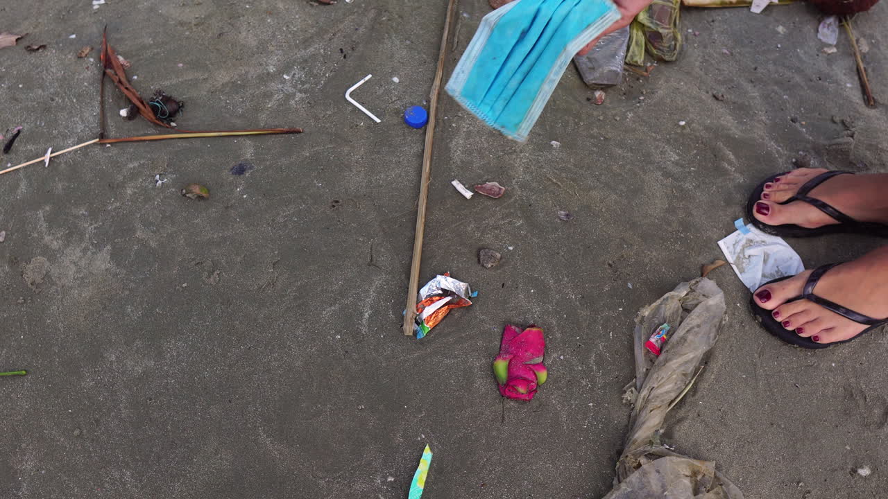 Ragazza raccoglie mascherina e rifiuti di plastica sulla spiaggia