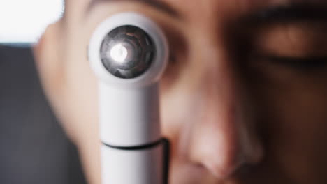 woman using otoscope for an examination, close up