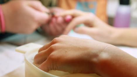 técnico de uñas dando a un cliente una manicura