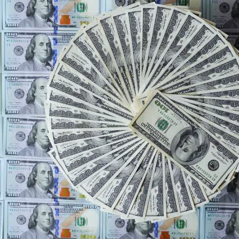 vista superior de la rotación del dinero. rico fondo de los billetes estadounidenses de cien dólares. billetes de dólar girando en el fondo de dólares de color.