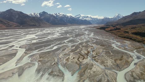 Panorama-Luftbogen-über-Dem-Flussdelta-Mit-Auffälligen-Texturen,-Schneebedeckten-Aoraki-Mount-Cook-Mountains-Im-Hintergrund