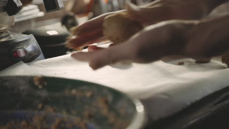 hands rolling cookie dough into balls before baking - close up