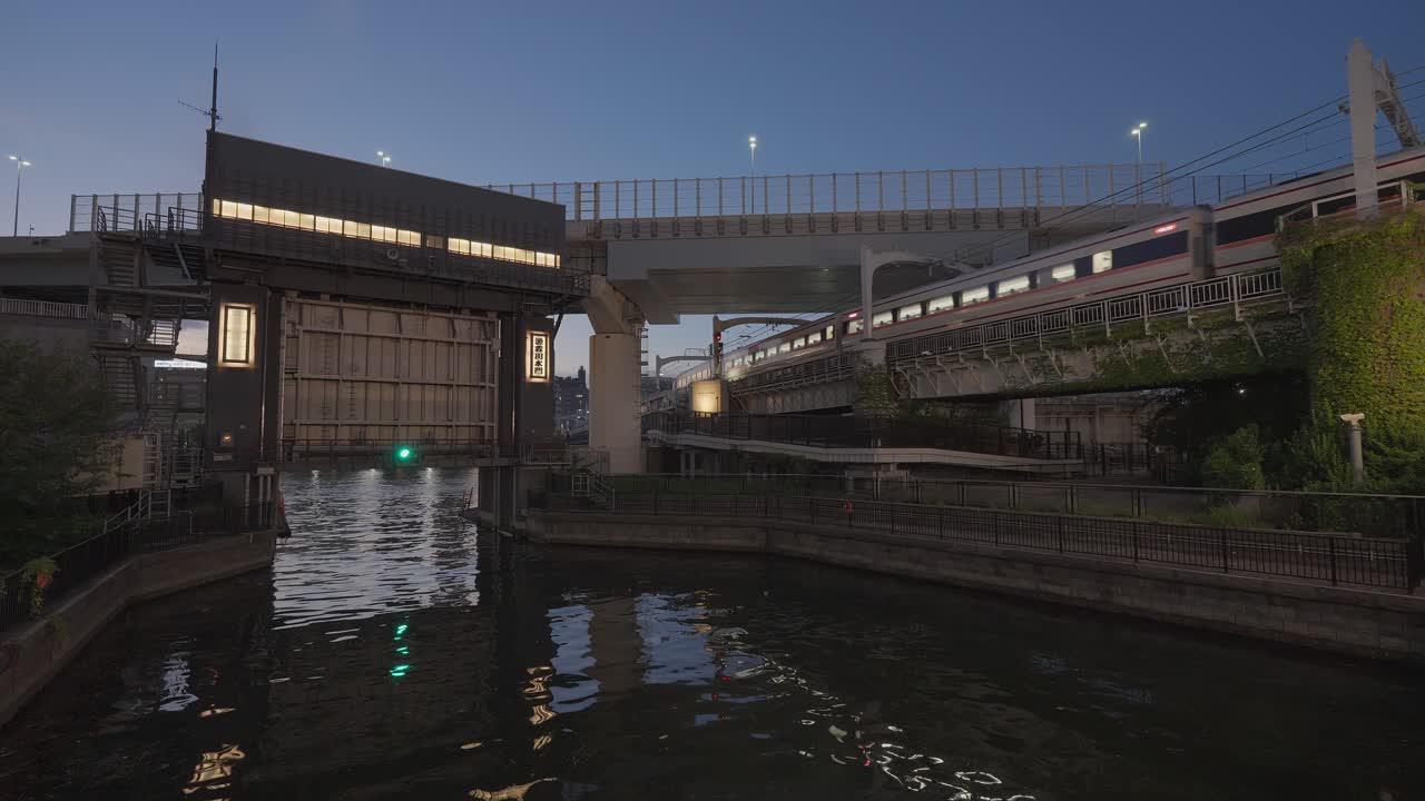 Nighttime view of a train crossing a bridge over a river