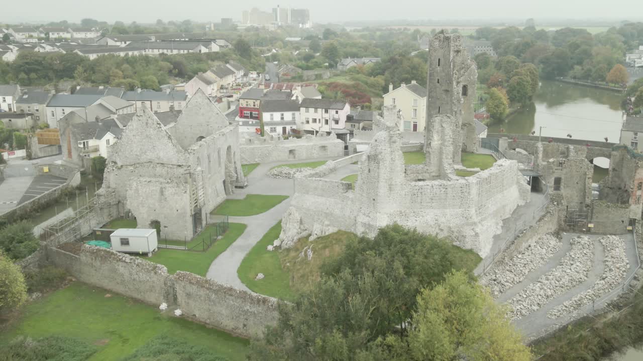 Desmond castle ruins in askeaton, ireland, surrounded by trees and a small town, aerial view