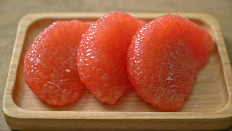 fresh red pomelo fruit or grapefruit on plate