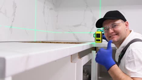 using a construction laser a man collects kitchen furniture repair in the house using a construction laser a man collects kitchen furniture repair in the house