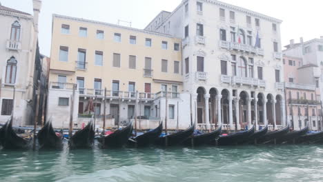 Passing-many-moored-Gondolas-on-the-Grand-Canal,-winter-day-in-Venice