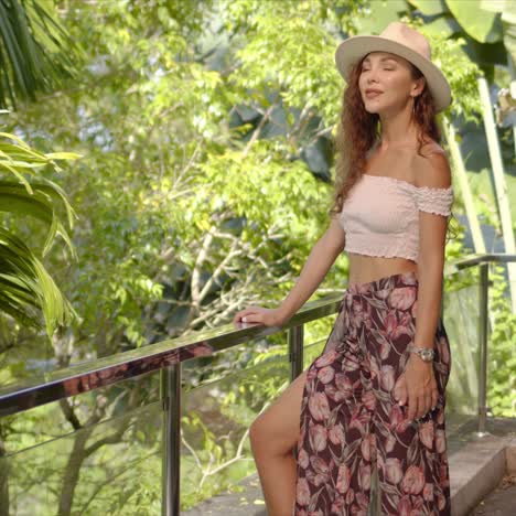 Stylish-female-resting-on-balcony-near-tropical-plants