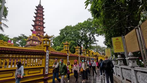 tourists walking through a pagoda's ornate gate