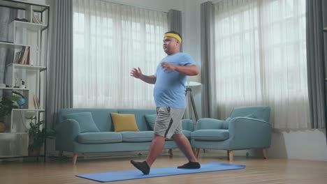 hombre gordo asiático haciendo yoga en la alfombra en casa