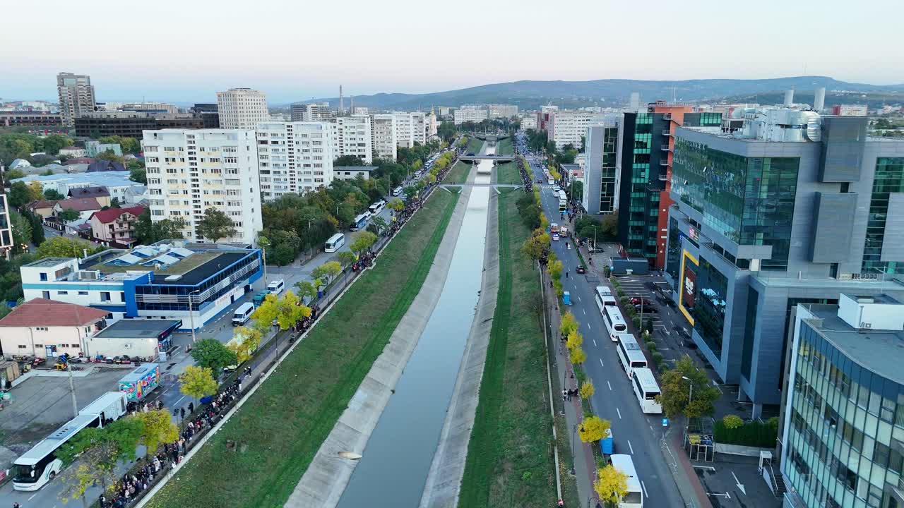 Drone footage of Iasi cityscape following the Bahlui River, showing a mix of modern architecture, office buildings, and urban life in Eastern Romania