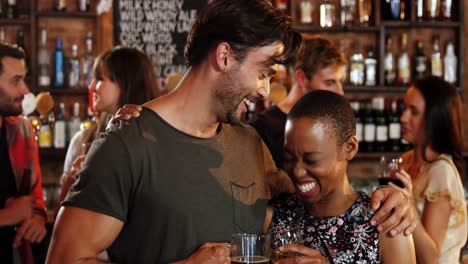 pareja romántica interactuando mientras tienen un vaso de alcohol