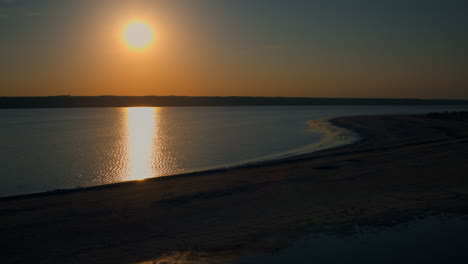 golden sunset reflecting at sea water surface. aerial sand beach morning sunrise