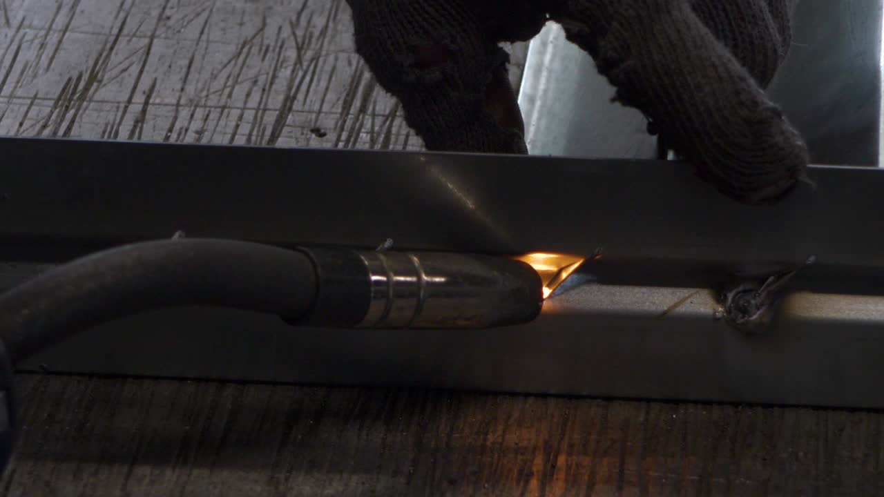 Welder works in metal construction - construction and processing of steel components