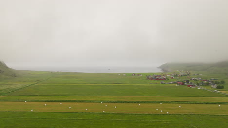 Aerial-View-Of-Green-Meadow-In-Unstad-Village-On-A-Foggy-Morning-In-Vestvagoya-Island,-Norway