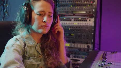 woman working with mixing desk in recording studio