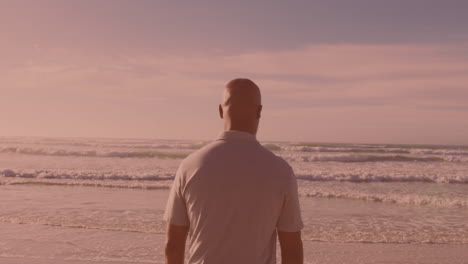 Rear-view-of-african-american-senior-man-walking-at-the-beach