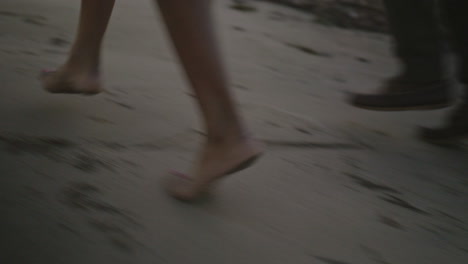 close up of a couple's feet walking the beach