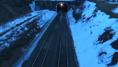 high angle over a freight train going through a tunnel at night in the winter