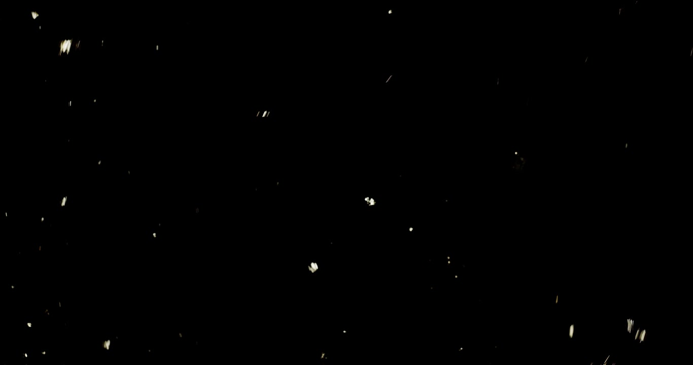 Wide shot as fine gold flakes fall in slow motion and land on black background.