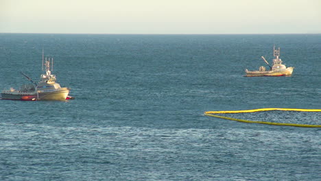 emergency boats lay out a protective net after the massive beach cleanup effort following the refugio oil spill 1