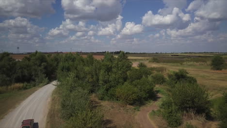 Aerial-rising-shot-with-an-antique-car-driving-a-country-road